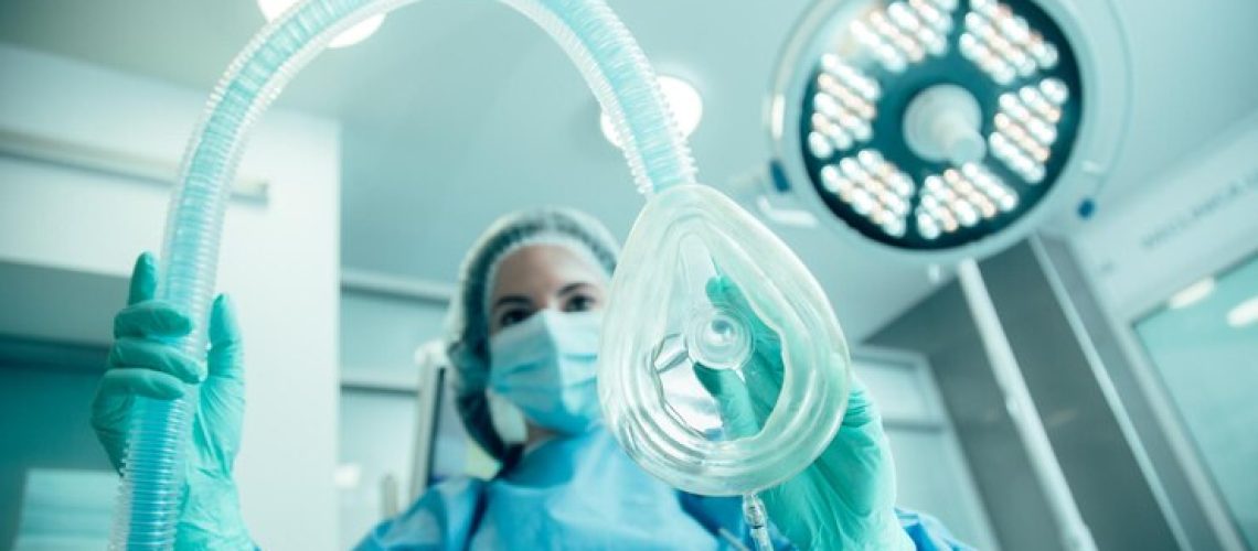 medica-em-pe-na-sala-de-cirurgia-se-preparando-para-colocar-seu-paciente-sob-narcose_376548-4399