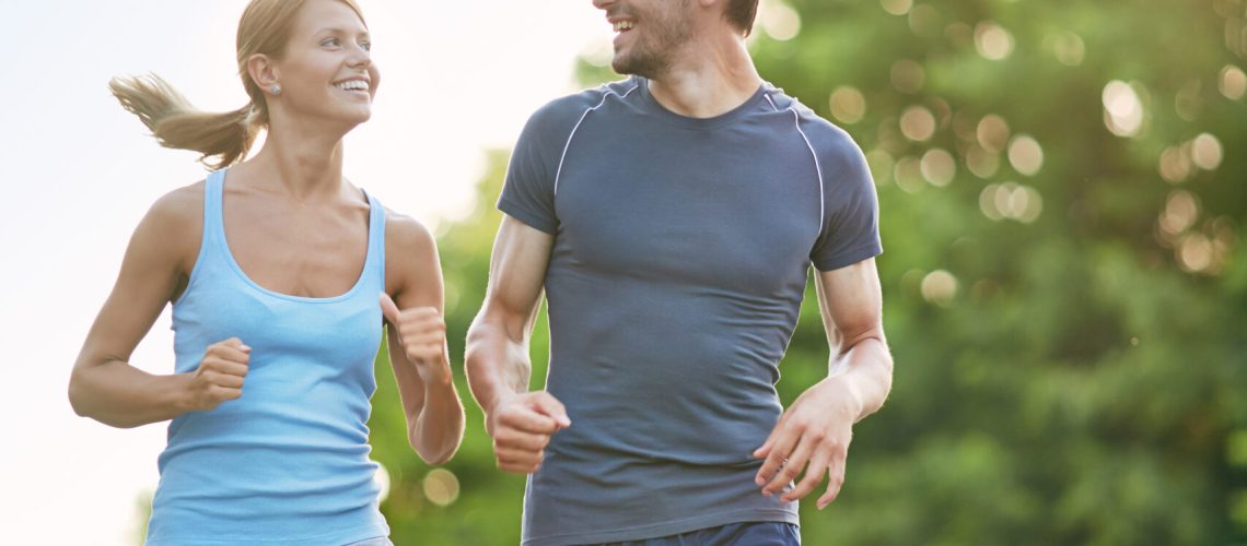 Photo of happy couple running outdoors